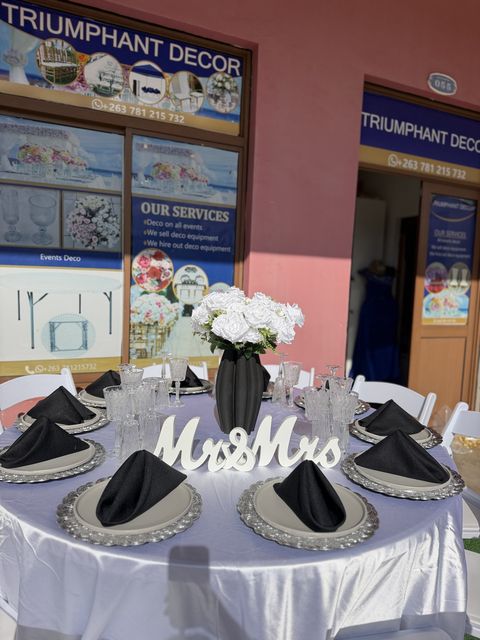 Wedding top table styled with a "Mr & Mrs" sign, black napkins and silver chargers
