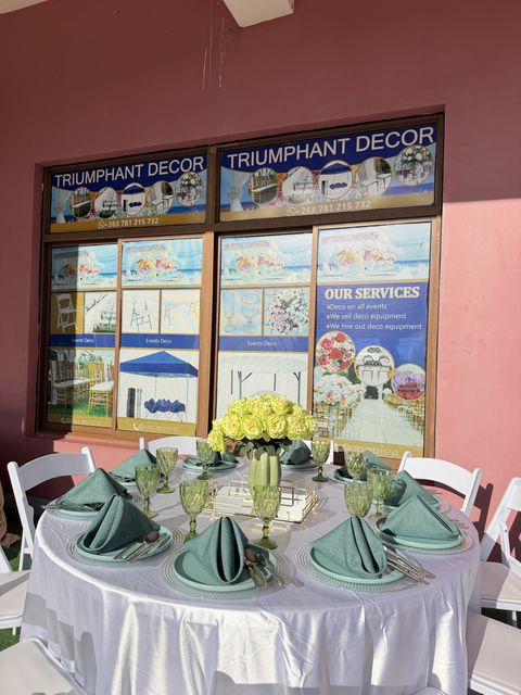 Round table with sage green napkins and silver chargers on white linen, by Triumphant Events