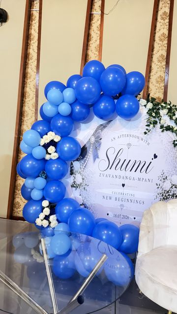 Blue and white balloon arch beside an "An Afternoon with Shumi" welcome sign, by Triumphant Events