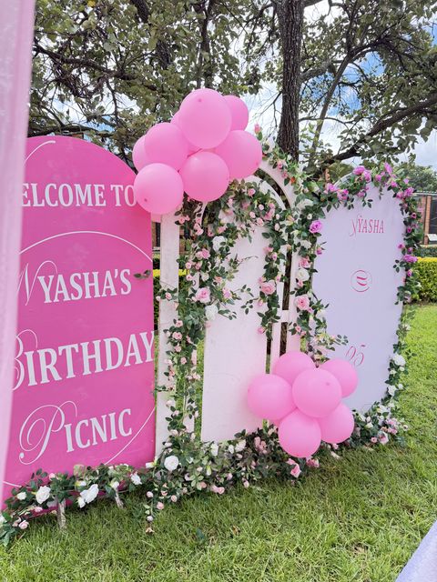 Close-up of the Nyasha's Birthday Picnic backdrop with pink balloon clusters