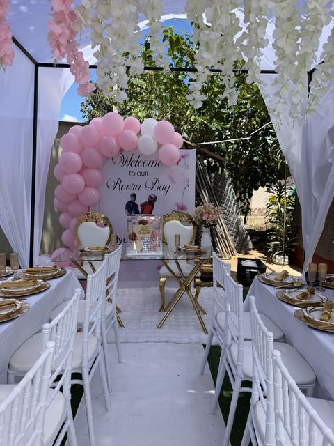 "Welcome to Our Roora Day" sign framed by a pink balloon arch