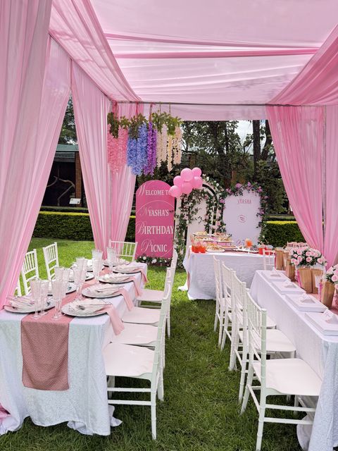 Pink tent picnic setup with hanging wisteria decor, by Triumphant Events