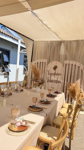 Close-up of the Tigashire Vakwasha signage with pampas grass and a terracotta charger
